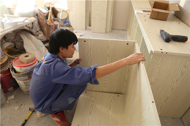 左右手衣柜安裝師傅正在給客戶(hù)家安裝定制衣柜